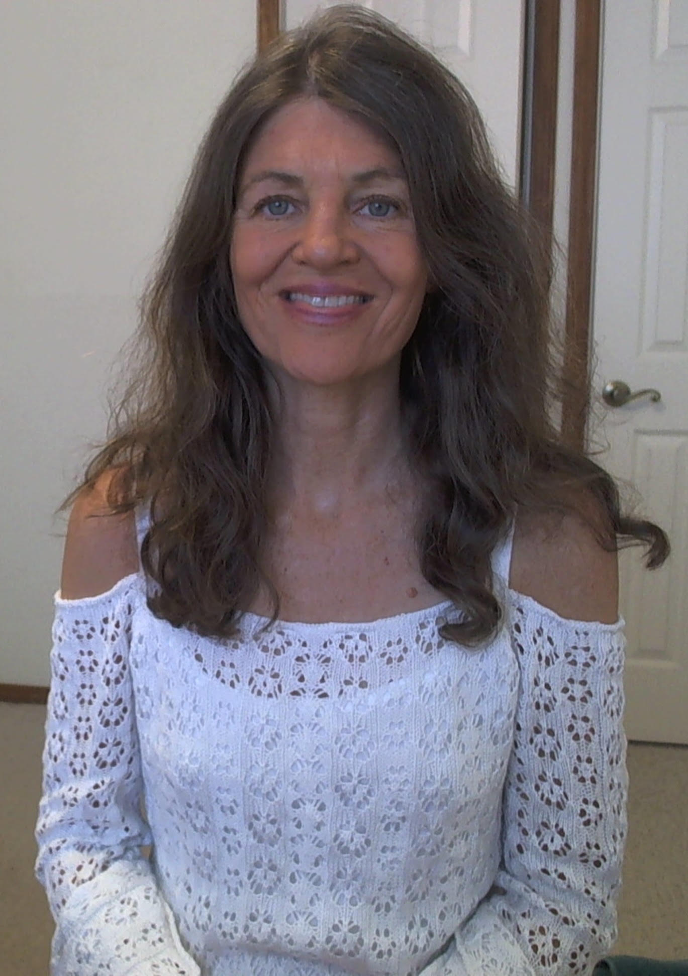 Laurie Moore, LMFT, smiling in a white lace top
