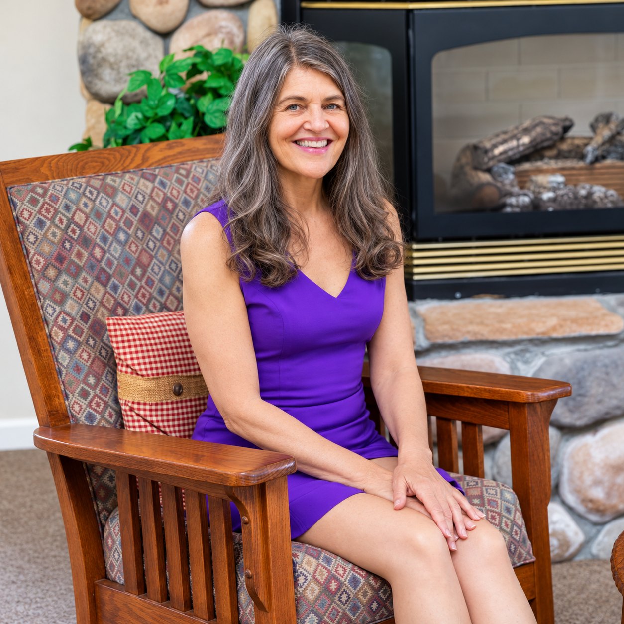 Laurie Moore, LMFT, seated in an armchair beside a stone fireplace